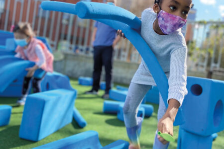 Child playing and building with foam pieces at KidsQuest museum.
