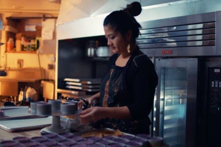 Chera Amlang making ube cheesecake in the kitchen of Hood Famous Bakeshop, a scene from an episode of Family Style on VISITSEATTLE.tv
