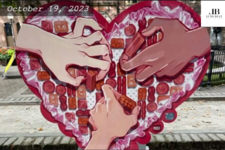 Heart shaped art piece with pink rims and three hands in the middle.