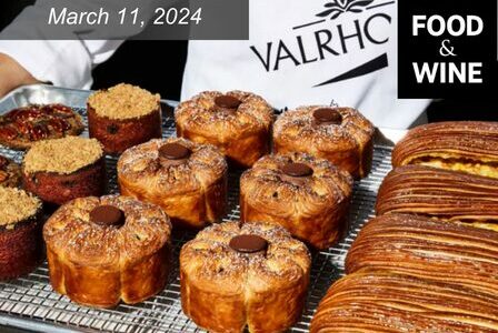 A chef holds a tray of freshly baked pastries, including round croissants topped with chocolate and sugar, and long flaky pastries. The text reads 
