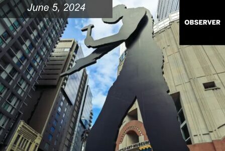 Large moving sculpture of man holding a hammer outside of Seattle Art Museum