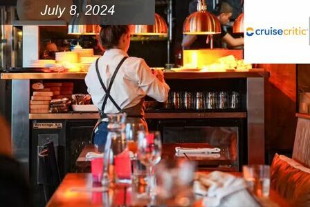 Wine bar staff member dressed in white button down shirt and suspenders tends to a bar.