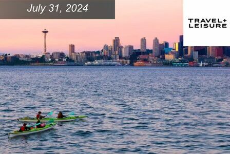 Sea kayakers float in Elliott Bay at sunset, looking onto the Seattle skyline and Space Needle