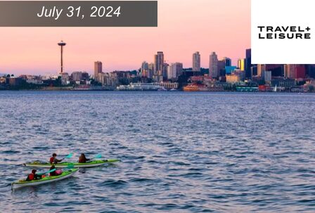 Sea kayakers float in Elliott Bay at sunset, looking onto the Seattle skyline and Space Needle
