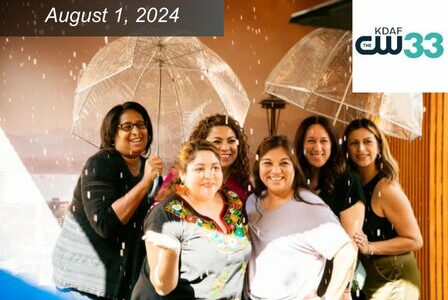 Group of women pose in the Seattle Rain Booth, holding umbrellas.