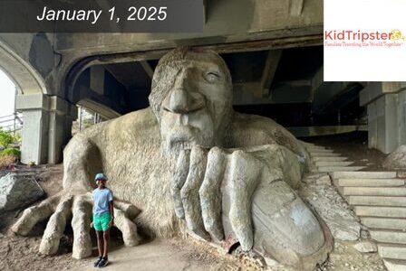 A person stands next to the Fremont Troll.