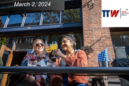 Two people clink glasses at an outdoor patio.