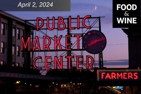 Pike Place's Public Market Center sign lit up at sunset.