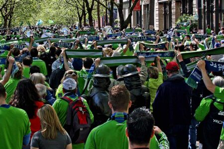 A crowd of people wearing green jerseys and holding scarves with 