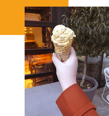 A hand holding up an ice cream cone at Sweet Alchemy